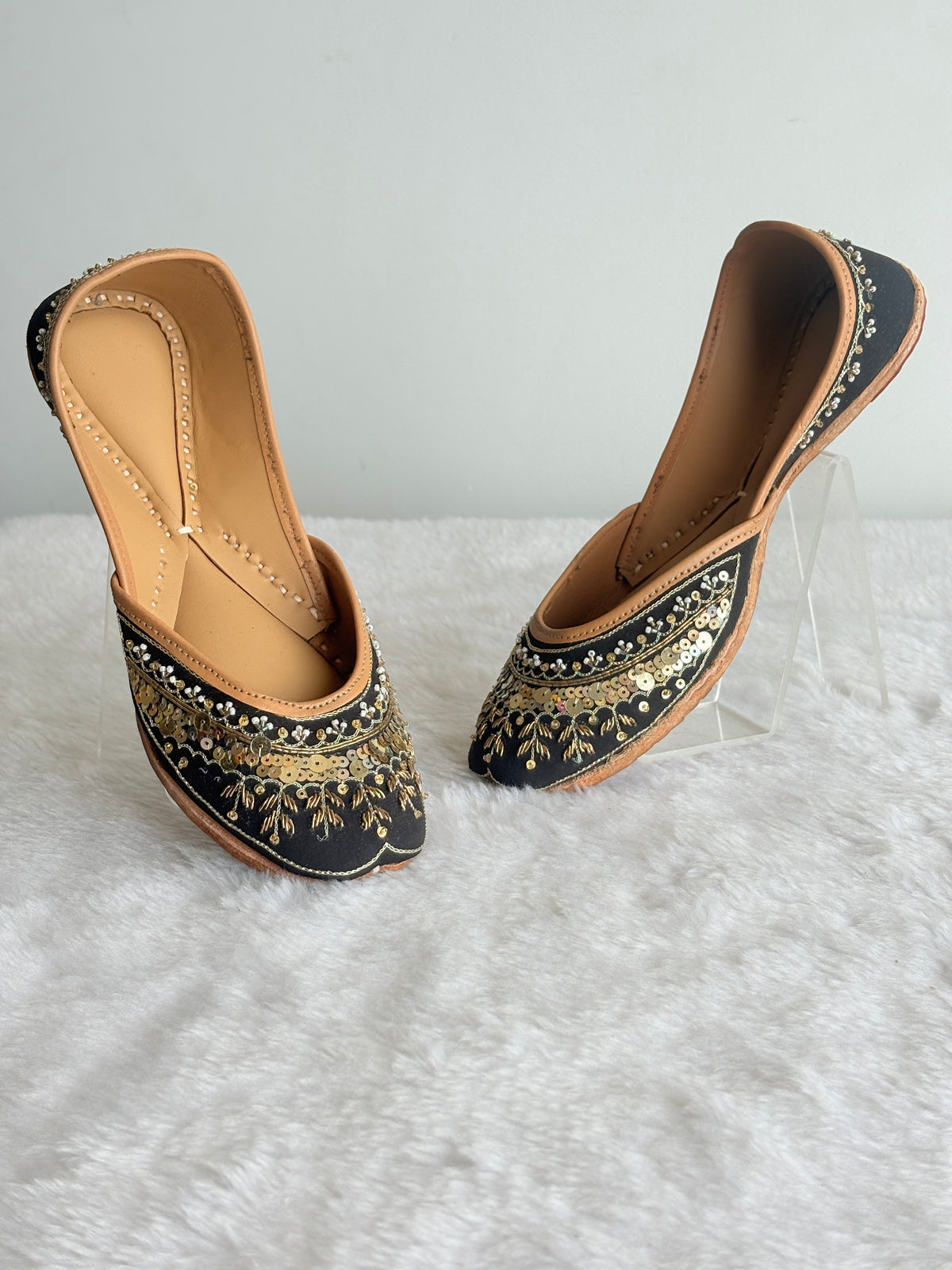 Noor black and gold juttis, angled view