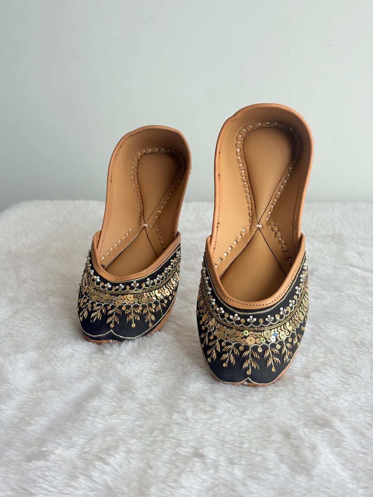 Noor black and gold juttis showing heel detailing