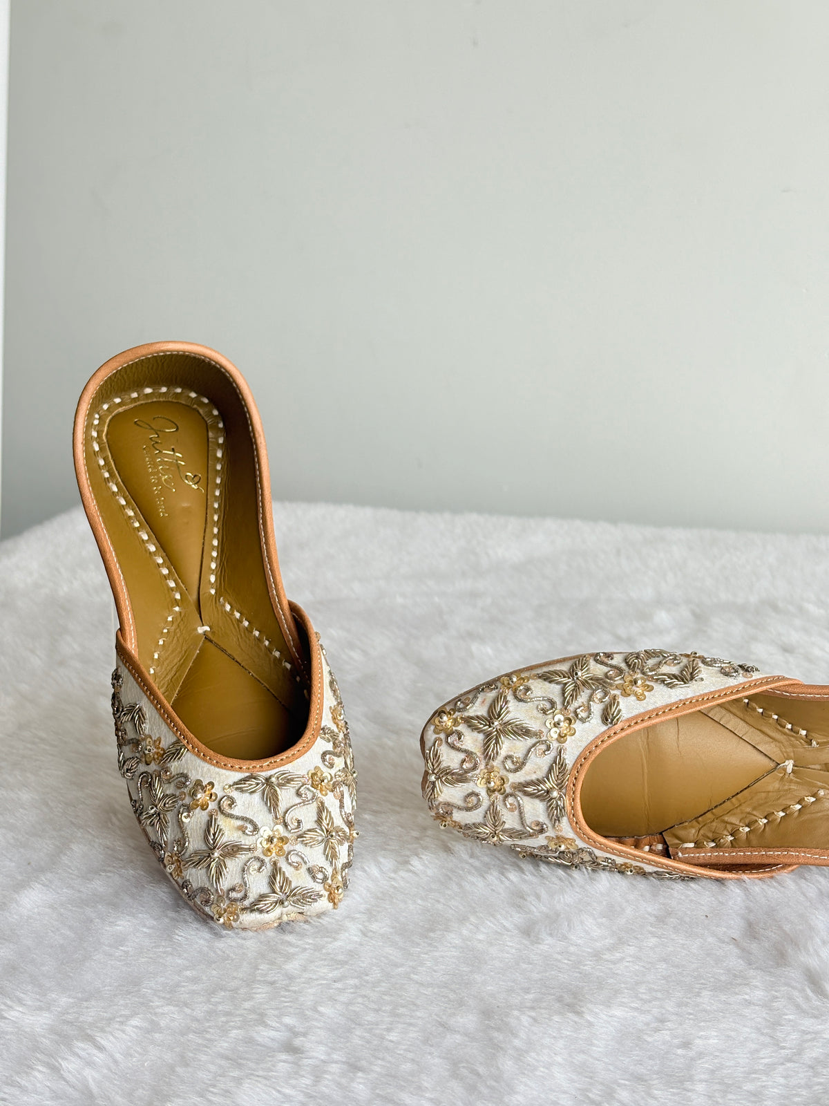 Zehra Ivory Juttis with metallic floral embellishments, angled front view