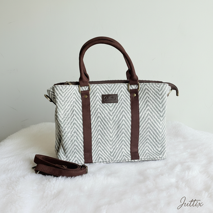 Geometric pattern handbag with brown leather handles and crossbody strap