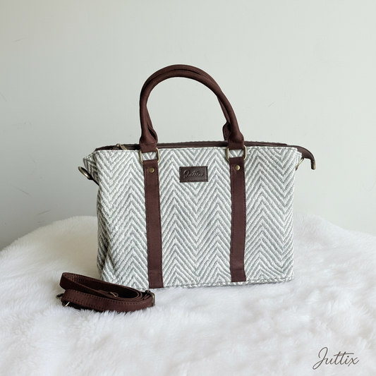 Geometric pattern handbag with brown leather handles and crossbody strap